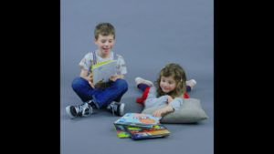 deux enfants qui lisent et une pile de livres