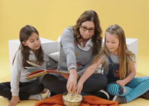 deux enfant et un parent font de la lecture pop corn.