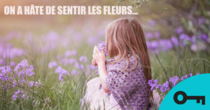 Un mème d'une petite fille qui sent une fleur dans un champ
