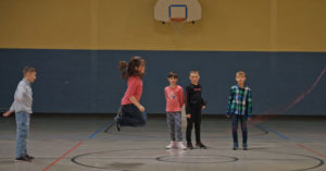 Des enfants qui jouent à la corde à sauter.