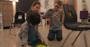 Des enfants enlèvent des épingles à linge d'une corde et calculent leurs points.