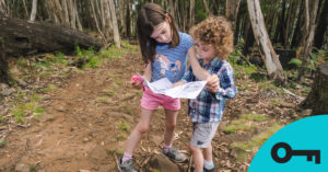 Deux enfants lisent une carte en faisant de la randonnée
