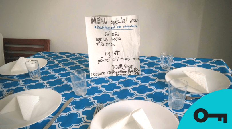 Un menu écrit à la main au centre d'une table bien montée.
