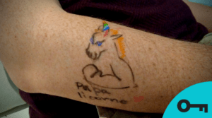 Un papa avec un tatouage temporaire de licorne fait à la main.