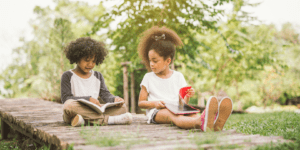 Deux enfants qui lisent des livres dans un parc.