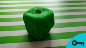 Un gros dé vert fait de pâte à modeler.