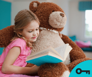 Une fillette lit un livre à son gros nounours.