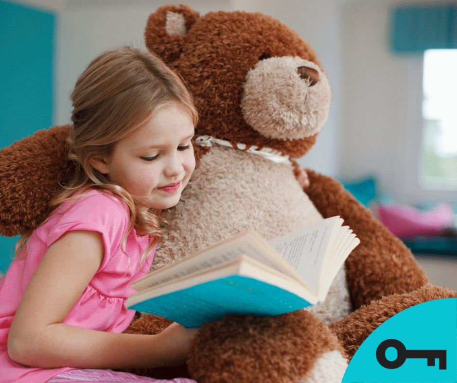 Une fillette lit un livre à son gros nounours.